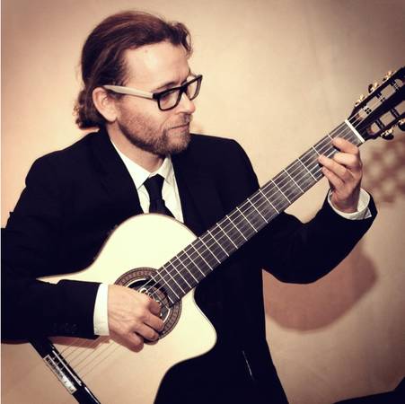 John Clarke performing classical guitar at a formal event